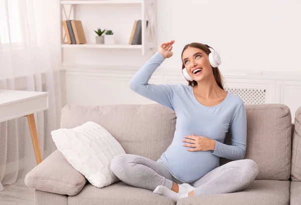 Cheerful Mother-To-Be In Headphones Listening To Music Sitting On Sofa — Stock Photo, Image