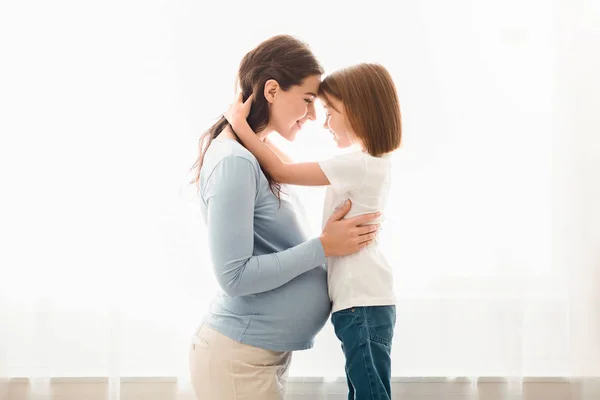 Esperando que madre e hija pequeña se abrazen en casa —  Fotos de Stock