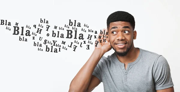 Curious black guy trying to overhear information, holding hand near ear — 스톡 사진