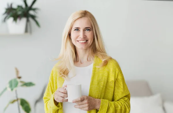 Heureuse femme d'âge moyen se reposant avec une tasse de thé — Photo