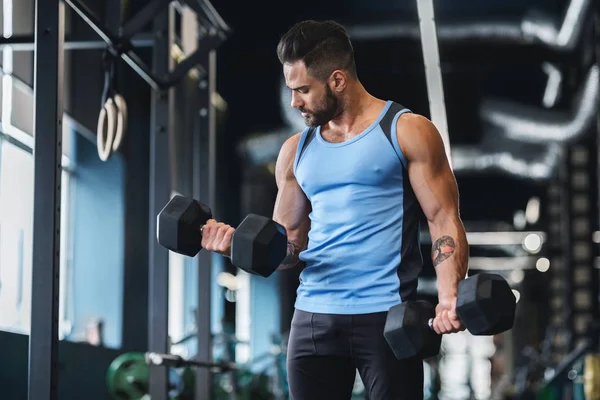 Hombre musculoso fuerte haciendo ejercicios con pesas —  Fotos de Stock