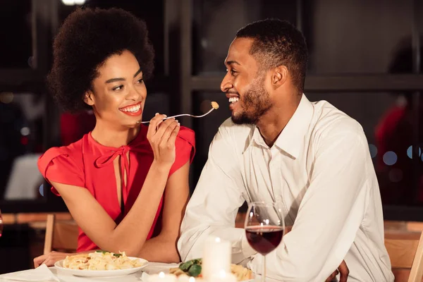 Amoroso casal afro ter data alimentando uns aos outros no restaurante — Fotografia de Stock