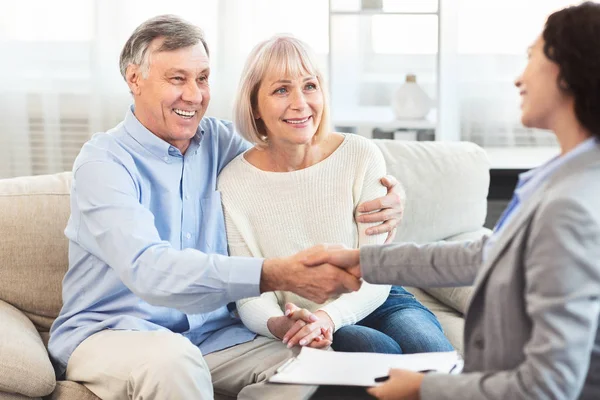 Weiblich realtor händeschütteln glücklich reif pärchen bei zuhause — Stockfoto