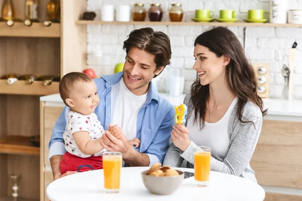 Millennial padres jugando con bebé niño en cocina — Foto de Stock