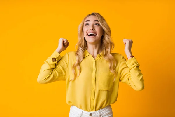 Emotional girl smiling and raising clenched fists in the air — Stock Photo, Image