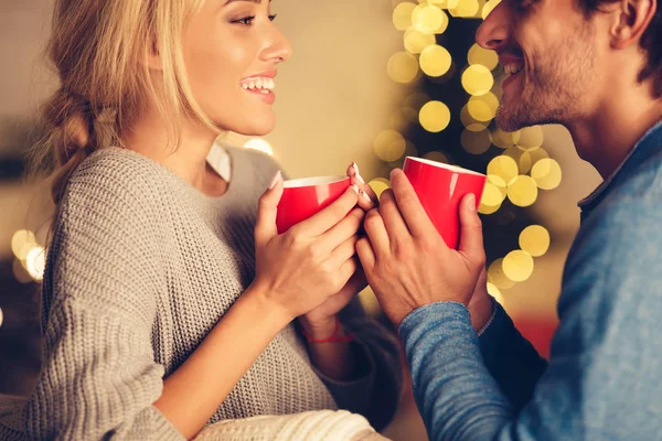 Χαριτωμένο ζευγάρι απολαμβάνοντας ζεστό τσάι την παραμονή των Χριστουγέννων — Φωτογραφία Αρχείου
