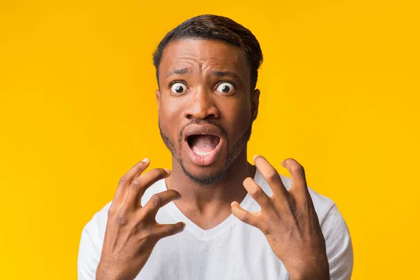 Medo afro cara gritando segurando as mãos perto do rosto, fundo amarelo — Fotografia de Stock