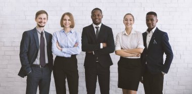 Kameraya poz veren başarılı meslektaşlar, beyaz tuğla duvar