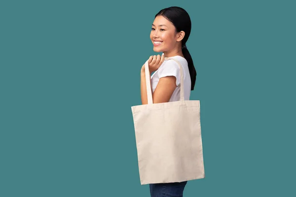 Mujer sosteniendo blanco Eco Shopper Bag sobre fondo turquesa — Foto de Stock