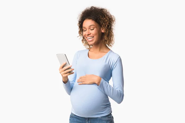 Wanita hamil positif pesan di telepon, latar belakang putih — Stok Foto