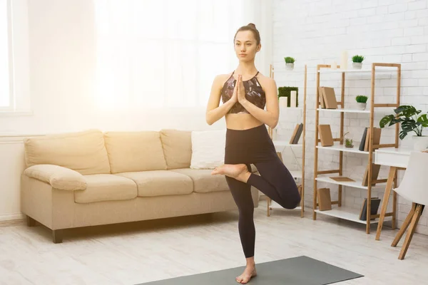 Sportig kvinna som gör yoga, övar trädpose — Stockfoto
