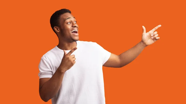 Excited black guy pointing two fingers aside — Stock Photo, Image