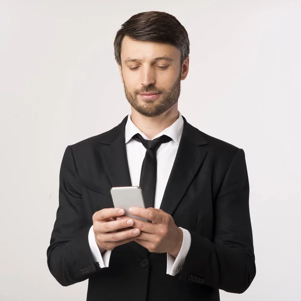 Confident Businessman Χρήση μηνυμάτων κινητό τηλέφωνο πάνω από λευκό φόντο — Φωτογραφία Αρχείου
