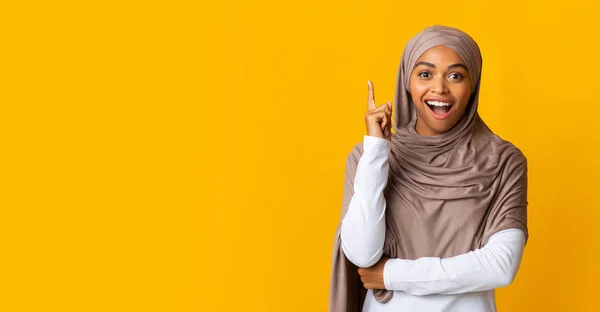 Overjoyed black muslim girl in hijab having idea, pointing finger up — Stock Photo, Image