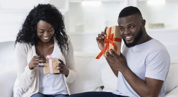 Happy black couple exchanging presents, celebrating their anniversary — Stock Photo, Image