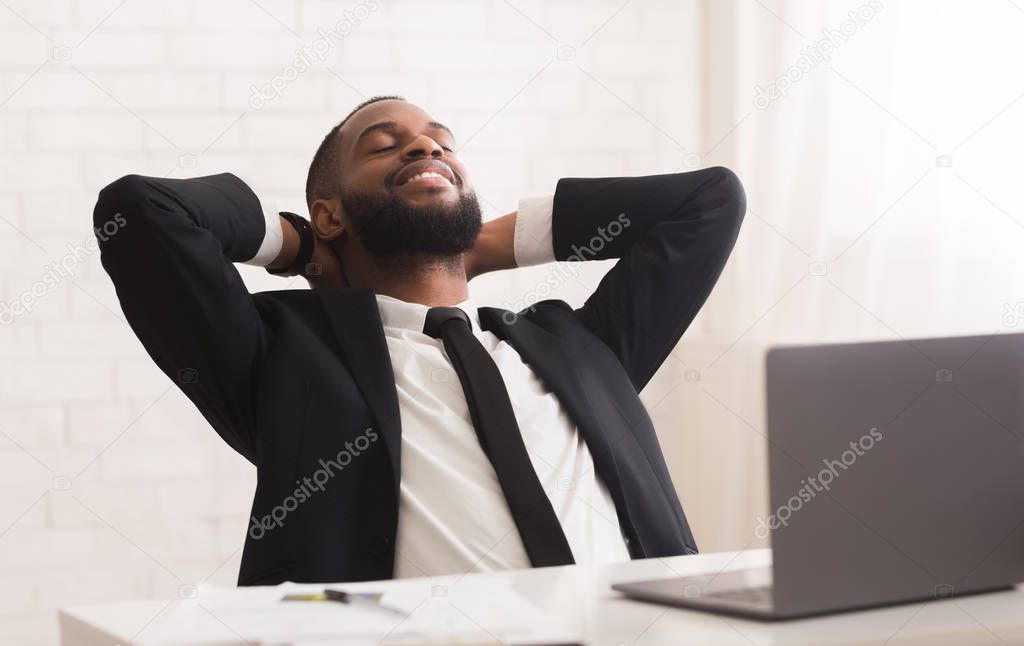 Happy black businessman resting after successful meeting