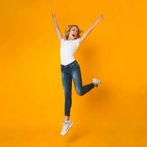 Håller på att bli galen. Kvinna hoppar och skriker på orange bakgrund — Stockfoto