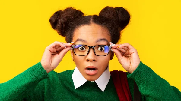 Amazed afro teenager with opened mouth touching glasses — Stock Photo, Image