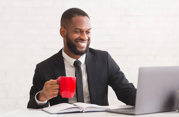 Souriant homme noir en costume boire du café dans le bureau — Photo