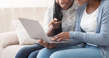 İki afro kadın dizüstü bilgisayarda oturmuş, internetten çöpçatanlık sitesine bakıyorlardı.