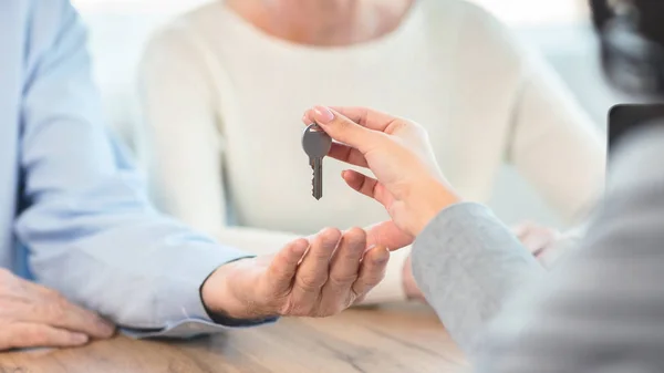 Feliz pareja de ancianos recibiendo la llave de su nuevo lugar —  Fotos de Stock