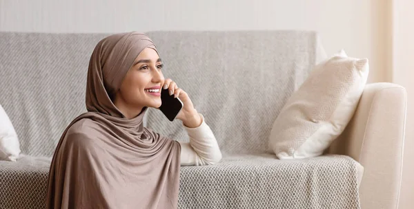 Fiatal arab lány fejkendőben beszél mobilon otthon. — Stock Fotó