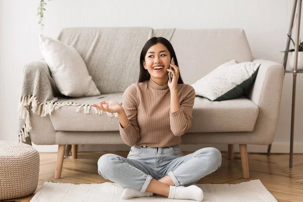 Llena de alegría chica asiática hablando en el teléfono celular con su amigo — Foto de Stock