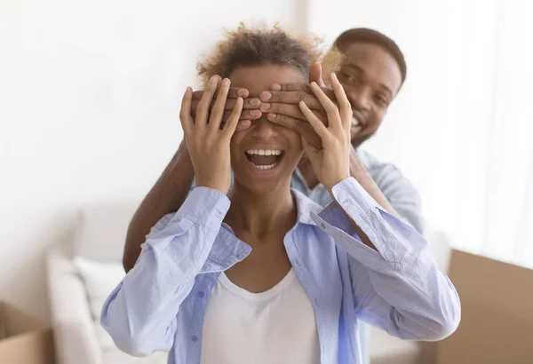 Afro-americano homem cobrindo esposas olhos antes de mostrar seu apartamento — Fotografia de Stock