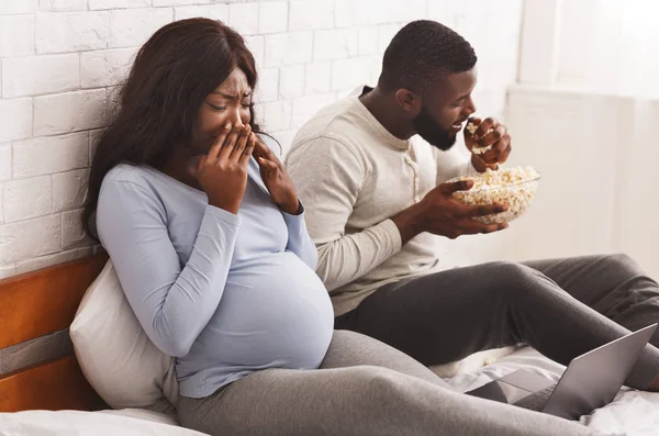 Negro chico comer palomitas de maíz mientras embarazada girando lejos — Foto de Stock