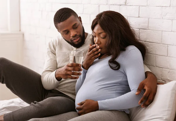 Marido dando a sua esposa grávida doente copo de água — Fotografia de Stock