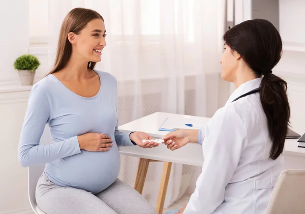 Therapist Giving Pregnant Woman Prescribed Medicines Sitting In Office — Stock Photo, Image