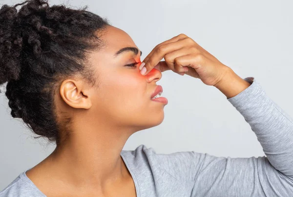 Indignant young woman touching her nose bridge — Stock Photo, Image