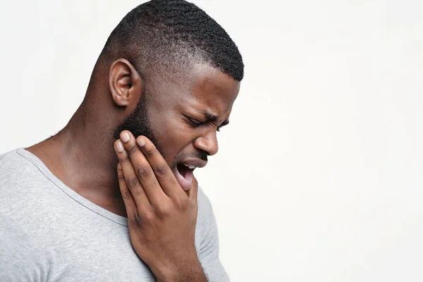 Jovem com dor de dente aguda, segurando a mandíbula — Fotografia de Stock