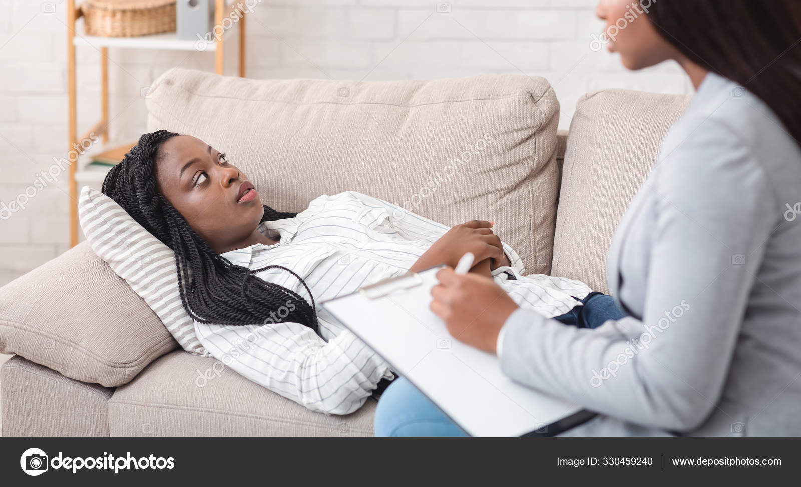 Депрессивная черная женщина лежит на диване в офисе психолога стоковое фото  ©Milkos 330459240