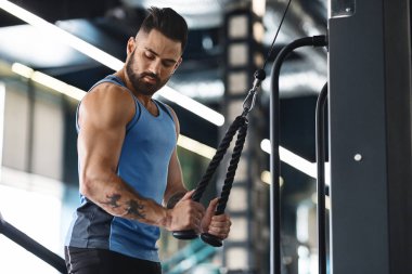 Spor salonunda idman yapan kaslı bir adam.