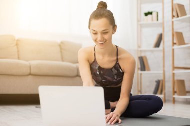 Sağlıklı bir kadın, yoga izliyor, eğitime hazırlanıyor.