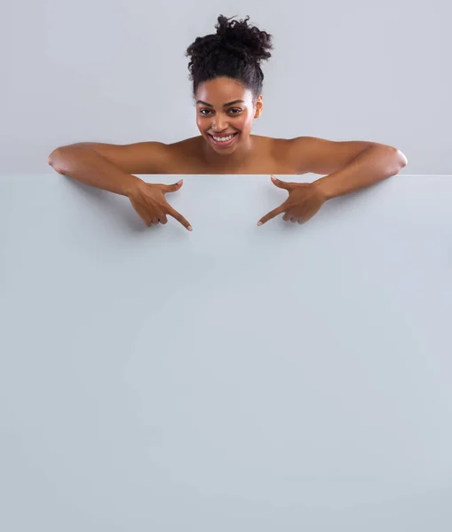 Happy black nude woman pointing at empty space — Stok Foto