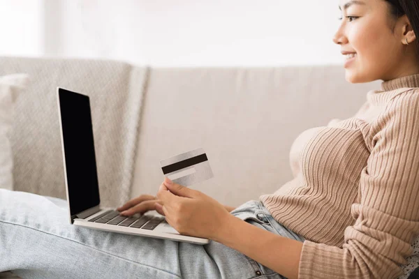 Онлайн оплата. Дівчина тримає кредитну картку за допомогою ноутбука — стокове фото