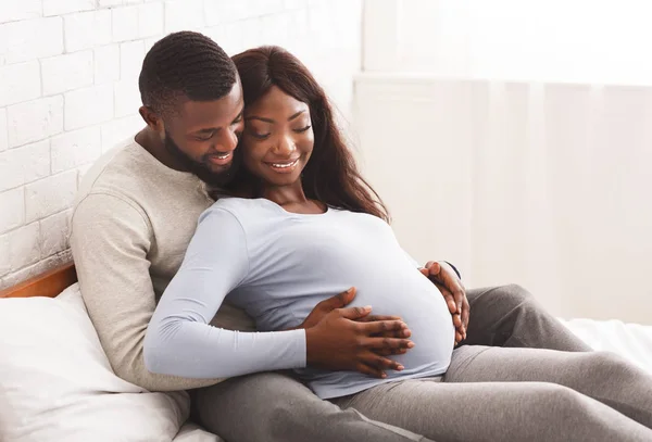 Casal apaixonado esperando bebê, abraçando e tocando barriga — Fotografia de Stock