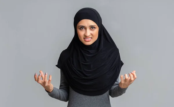 Egy dühös arab nő portréja hidzsábban, aki dühösen emeli fel a kezét. — Stock Fotó