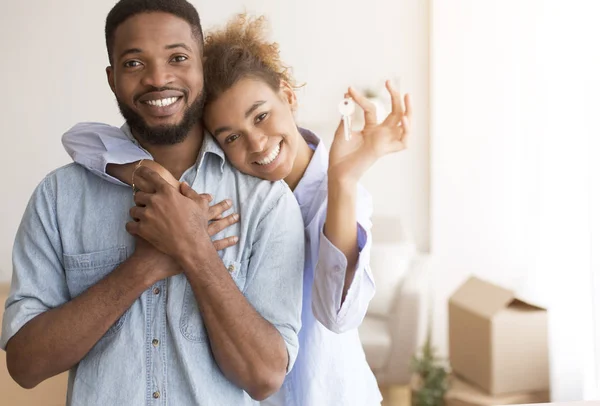 Paar mit neuem Hausschlüssel umarmt sich im eigenen Haus — Stockfoto