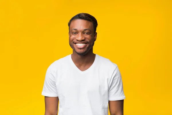 Negro chico en blanco camiseta sonriendo a cámara, estudio disparo —  Fotos de Stock