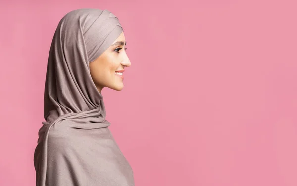 Perfil retrato de bela mulher árabe em hijab sobre fundo rosa — Fotografia de Stock