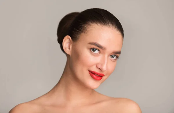 Mujer joven con labios rojos perfectos sonriendo a la cámara — Foto de Stock