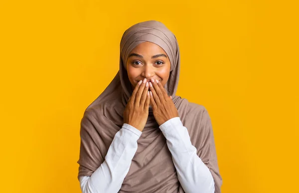 Surprised black muslim girl in headscarf covering her mouth with hands — Stock Photo, Image