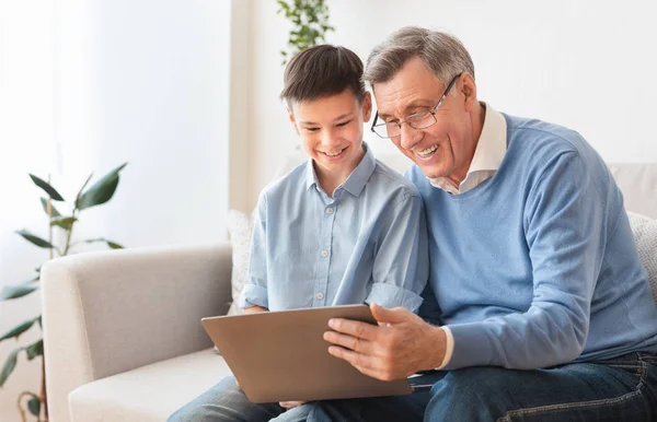 Дід і онук використовують ноутбук разом дивитися кіно в приміщенні — стокове фото