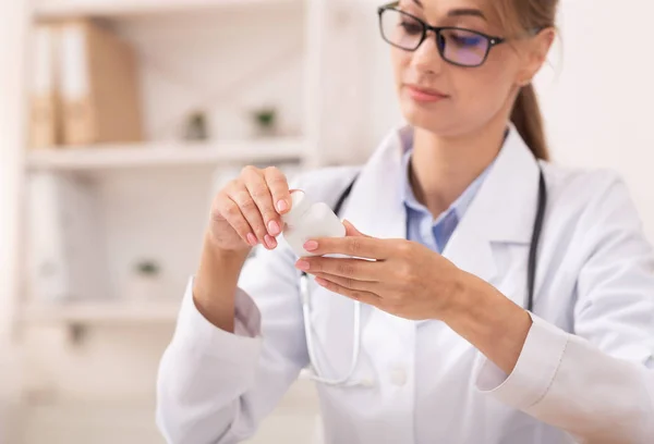 Médico segurando pílulas lendo os ingredientes da medicina no escritório — Fotografia de Stock