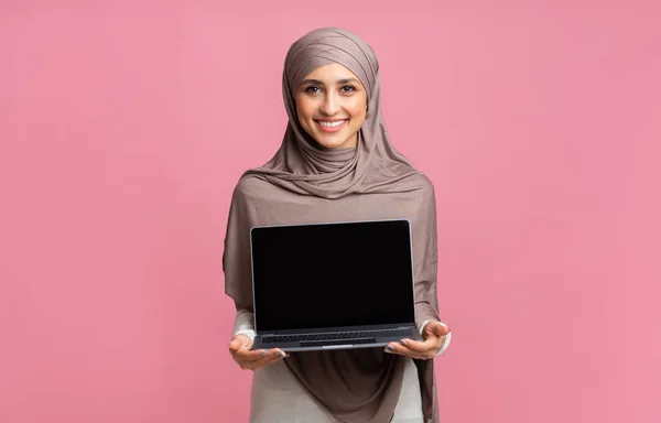 Smiling Arabic Girl In Hijab Holding Laptop Computer With Black Screen