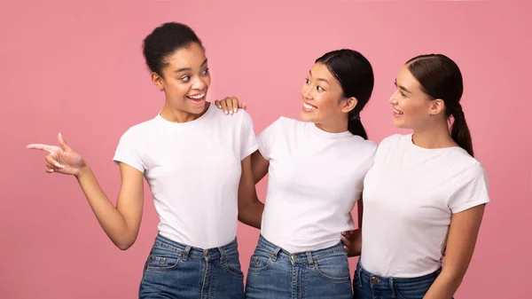 Meisje wijzend vinger uitnodigen vrienden op winkelen over roze achtergrond — Stockfoto
