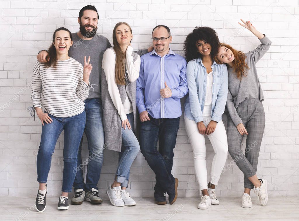 Group of friendly cheerful people embracing together